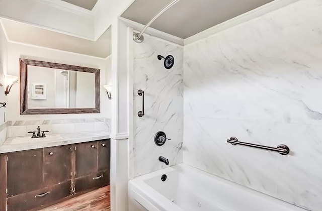 bathroom featuring vanity, crown molding, hardwood / wood-style flooring, and tiled shower / bath combo