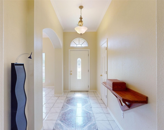 tiled foyer featuring crown molding