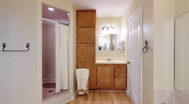 bathroom with vanity, hardwood / wood-style flooring, and walk in shower