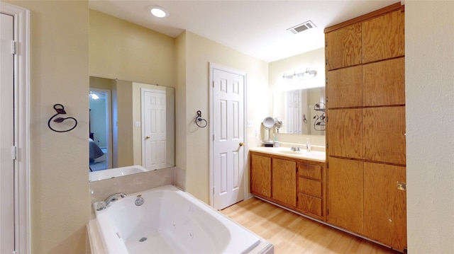 bathroom featuring hardwood / wood-style floors, vanity, and a bathtub