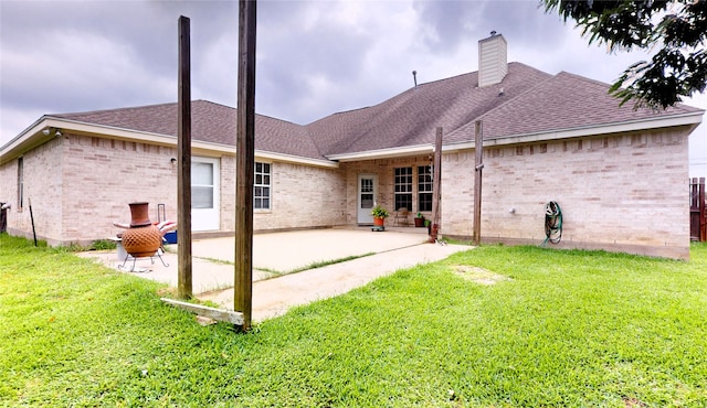 back of property with a yard and a patio