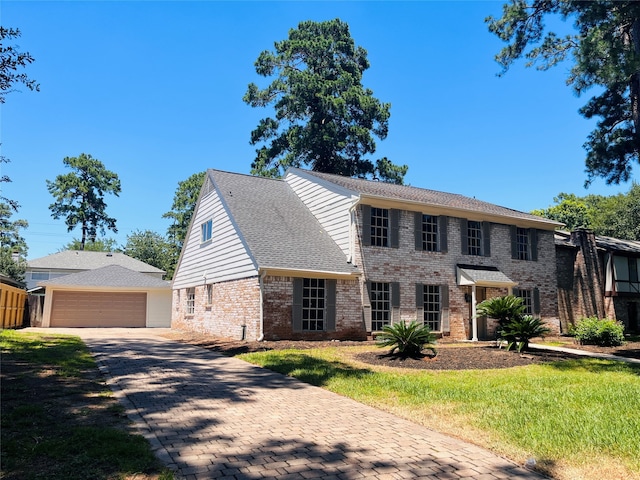 colonial home featuring a front yard and a garage