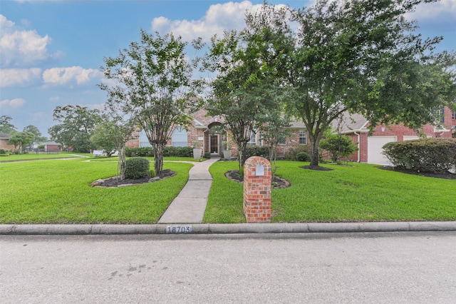 obstructed view of property with a garage and a front lawn