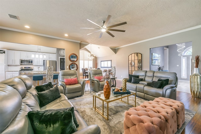 living room with ceiling fan with notable chandelier, a textured ceiling, crown molding, hardwood / wood-style flooring, and lofted ceiling