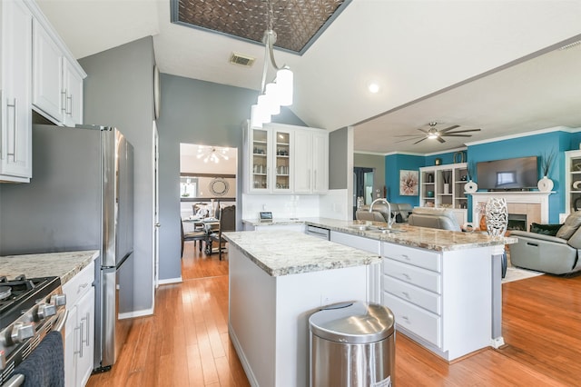 kitchen featuring a kitchen island, kitchen peninsula, sink, and white cabinetry