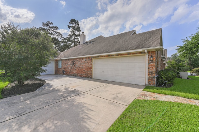 view of home's exterior with a garage and a lawn