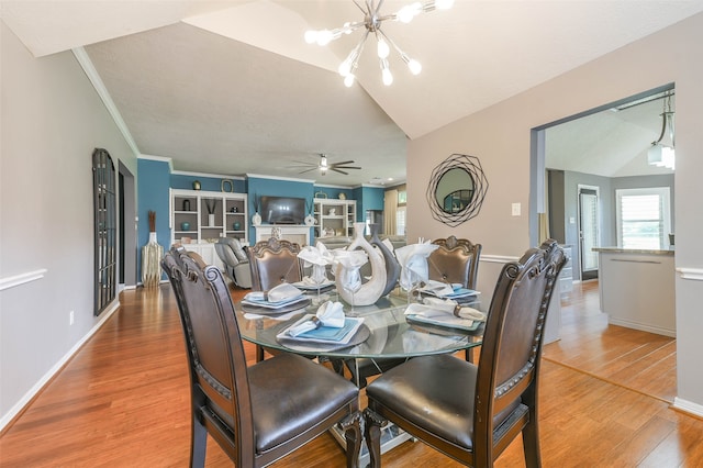 dining area featuring ceiling fan with notable chandelier, wood-type flooring, crown molding, and vaulted ceiling