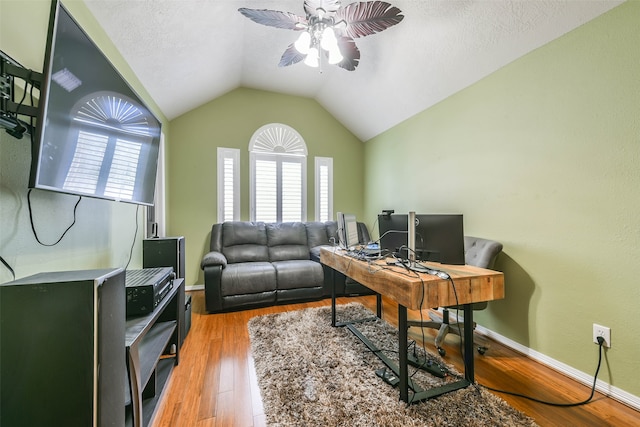 office area with a textured ceiling, hardwood / wood-style flooring, vaulted ceiling, and ceiling fan