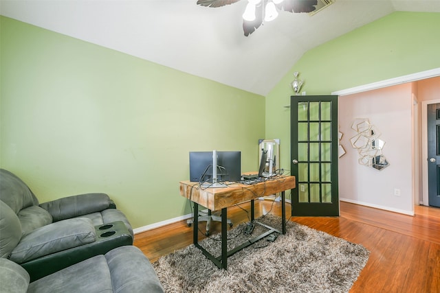 home office featuring ceiling fan, wood-type flooring, and vaulted ceiling