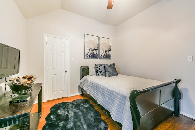 bedroom featuring ceiling fan, dark hardwood / wood-style floors, and lofted ceiling