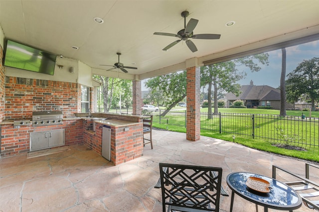 view of patio / terrace featuring a bar, area for grilling, and ceiling fan