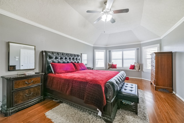 bedroom with multiple windows, wood-type flooring, vaulted ceiling, and ceiling fan