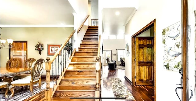 stairway featuring dark hardwood / wood-style flooring and ornamental molding