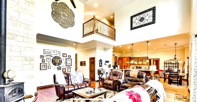 living room with ornamental molding, a wood stove, and hardwood / wood-style floors