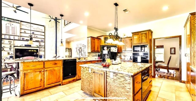 kitchen featuring a center island, light tile floors, pendant lighting, and black appliances