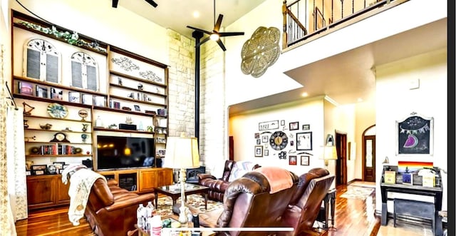 living room with high vaulted ceiling, ceiling fan, and hardwood / wood-style floors