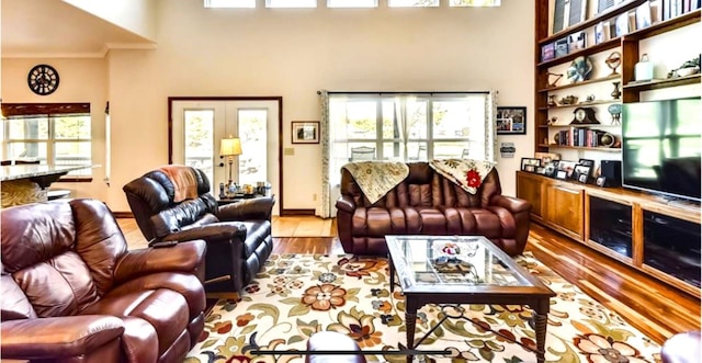 living room with a high ceiling, french doors, and wood-type flooring