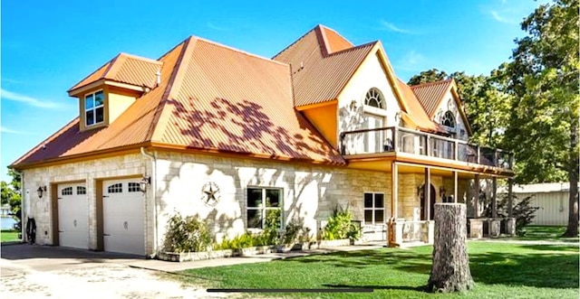 view of front of house featuring a balcony, a garage, and a front yard