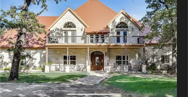 view of front of home with a front yard, covered porch, and a balcony