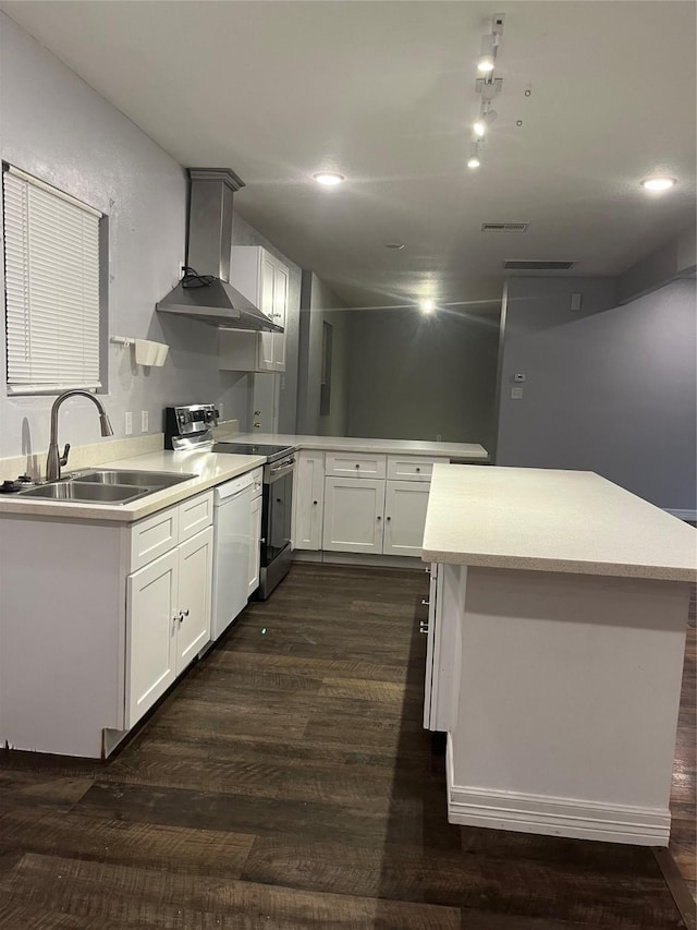 kitchen with white appliances, wall chimney range hood, sink, dark hardwood / wood-style floors, and white cabinetry