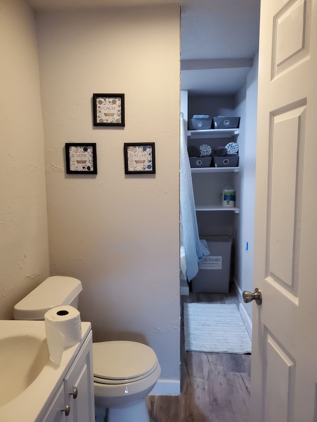 bathroom with vanity, toilet, and hardwood / wood-style floors