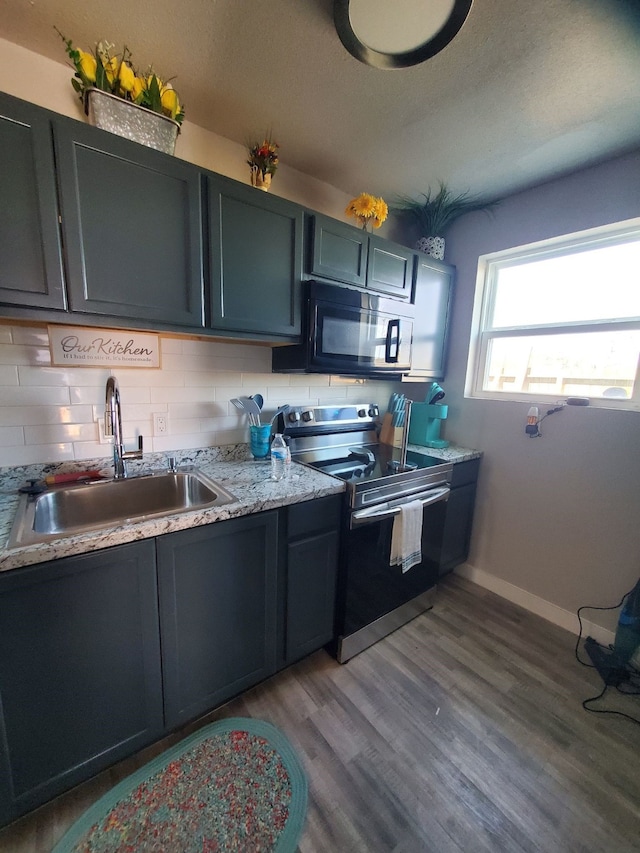 kitchen featuring sink, electric range, wood-type flooring, and backsplash