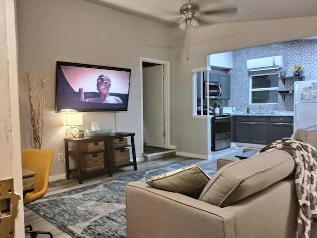 living room featuring sink, hardwood / wood-style flooring, lofted ceiling, and ceiling fan