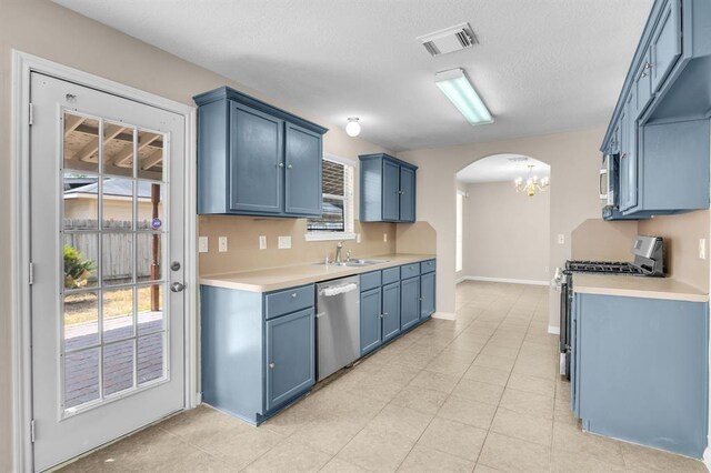 kitchen featuring stainless steel appliances, blue cabinetry, and light tile floors