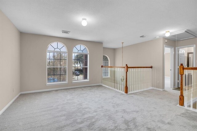 carpeted spare room featuring a textured ceiling