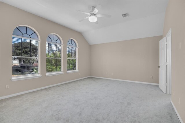 carpeted spare room with ceiling fan and lofted ceiling