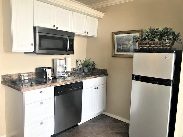 kitchen with sink, stainless steel appliances, crown molding, white cabinets, and dark tile patterned flooring