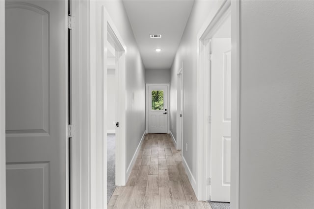 hallway with light hardwood / wood-style floors