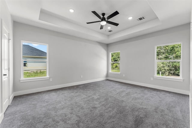 unfurnished room featuring carpet flooring, a raised ceiling, and ceiling fan