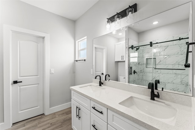 bathroom featuring a shower with shower door, wood-type flooring, and vanity