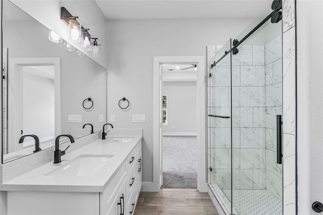 bathroom with wood-type flooring, vanity, and a shower with shower door