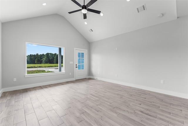 spare room featuring light wood-type flooring, high vaulted ceiling, and ceiling fan