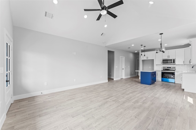 unfurnished living room featuring ceiling fan and light hardwood / wood-style floors