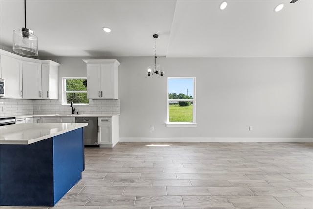 kitchen featuring hanging light fixtures, stainless steel appliances, white cabinetry, and plenty of natural light