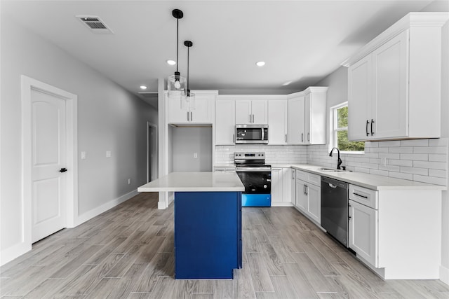 kitchen with a center island, white cabinets, stainless steel appliances, and decorative light fixtures