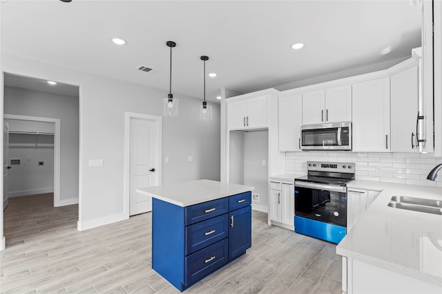 kitchen with a center island, blue cabinets, sink, white cabinetry, and stainless steel appliances