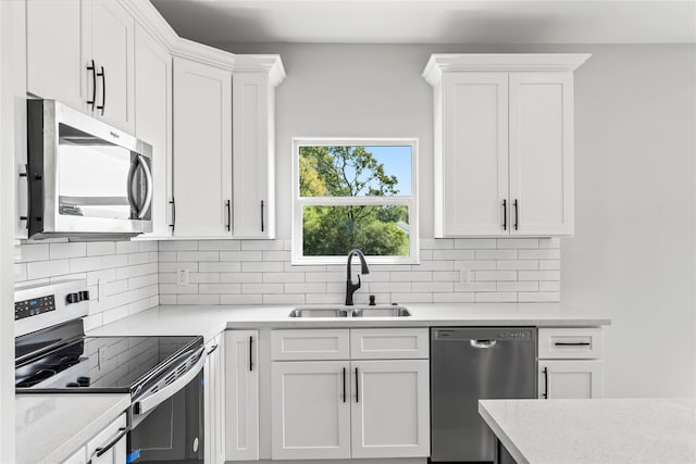 kitchen with backsplash, sink, white cabinetry, and stainless steel appliances