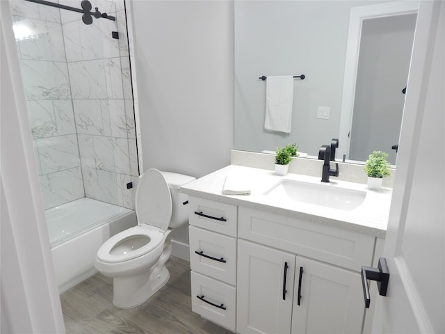 full bathroom featuring vanity, wood-type flooring, tiled shower / bath combo, and toilet