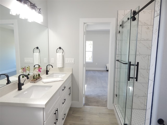 bathroom with hardwood / wood-style flooring, vanity, and an enclosed shower