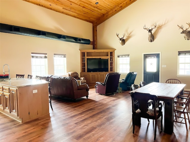 dining space featuring wood-type flooring, wooden ceiling, high vaulted ceiling, beamed ceiling, and sink