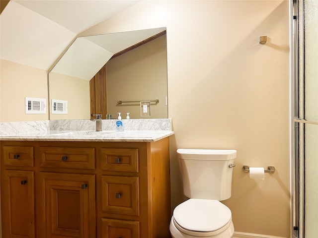 bathroom featuring vaulted ceiling, vanity, and toilet