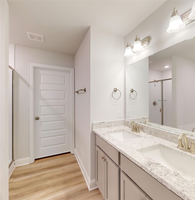 bathroom with vanity, a shower with door, and hardwood / wood-style floors