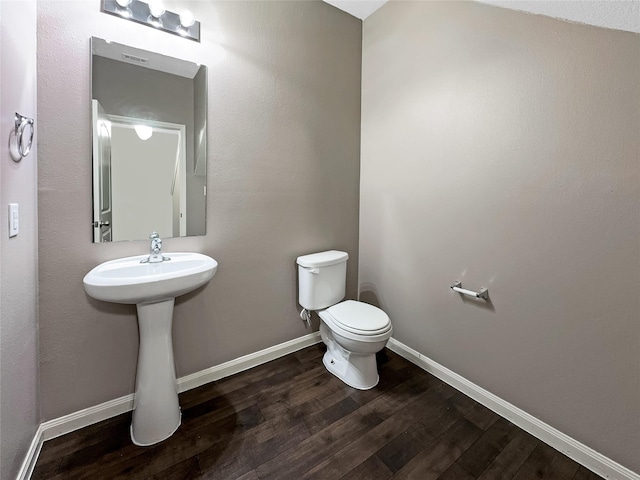 bathroom with hardwood / wood-style flooring, sink, and toilet