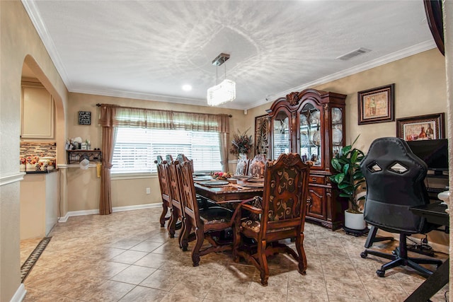 tiled dining room featuring ornamental molding and a textured ceiling