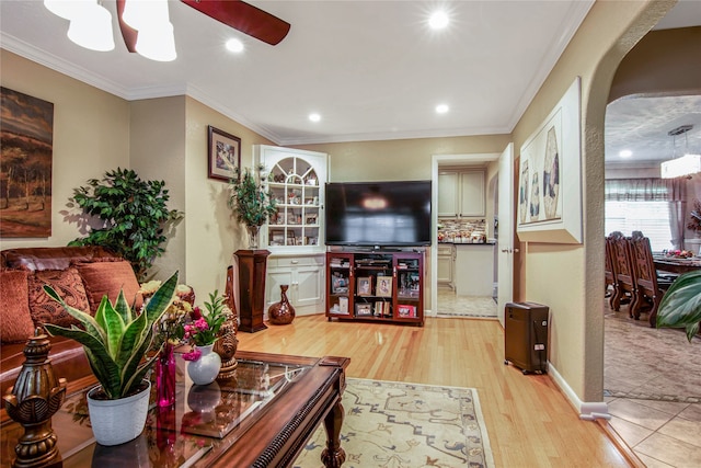 living room with ceiling fan, ornamental molding, and light hardwood / wood-style flooring