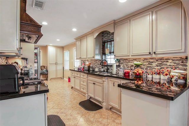 kitchen featuring sink, cream cabinetry, tasteful backsplash, and light tile floors